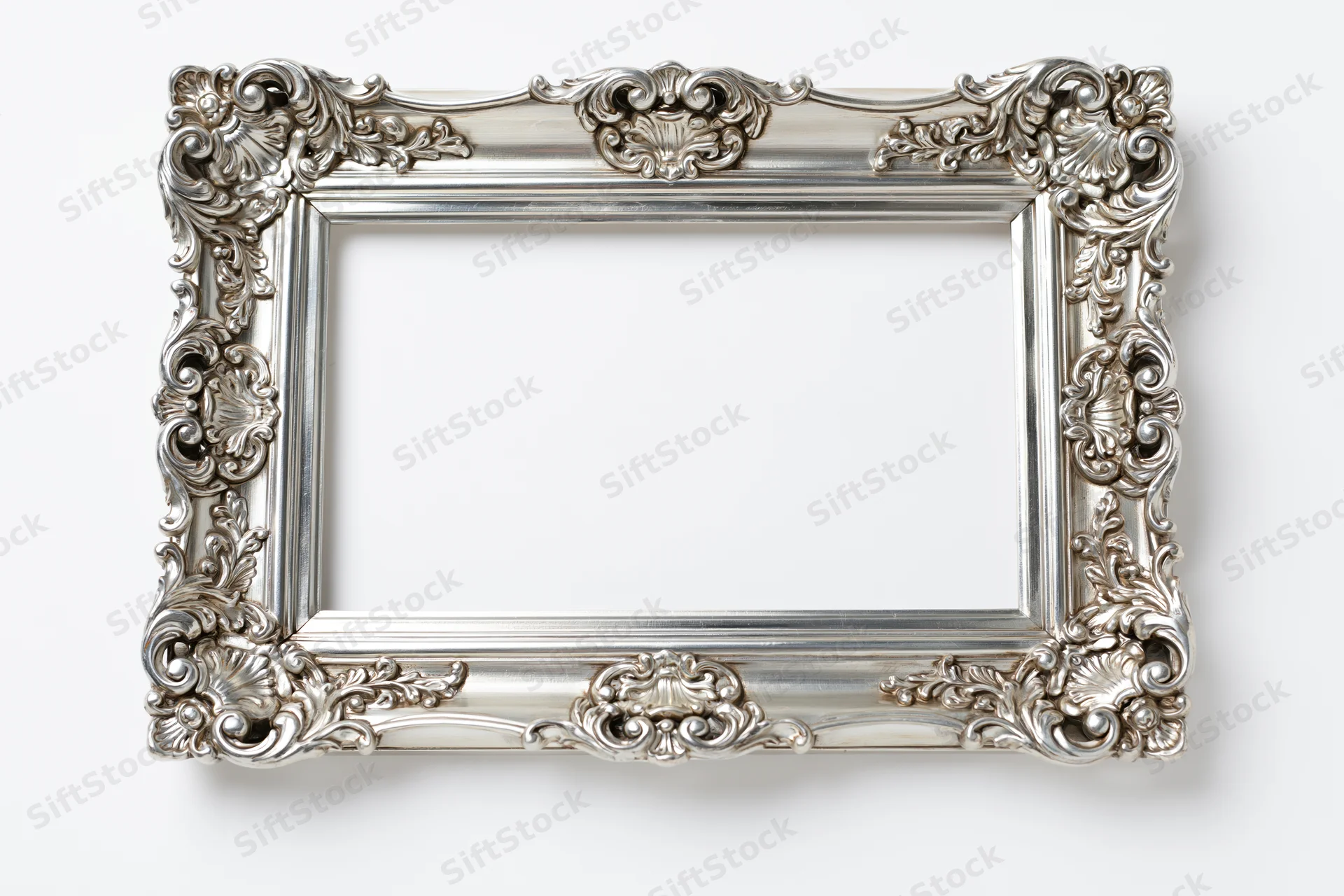 Ornate silver baroque picture frame with intricate scrollwork on white background