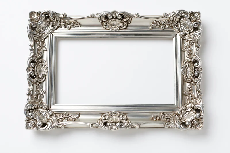 Ornate silver baroque picture frame with intricate scrollwork on white background