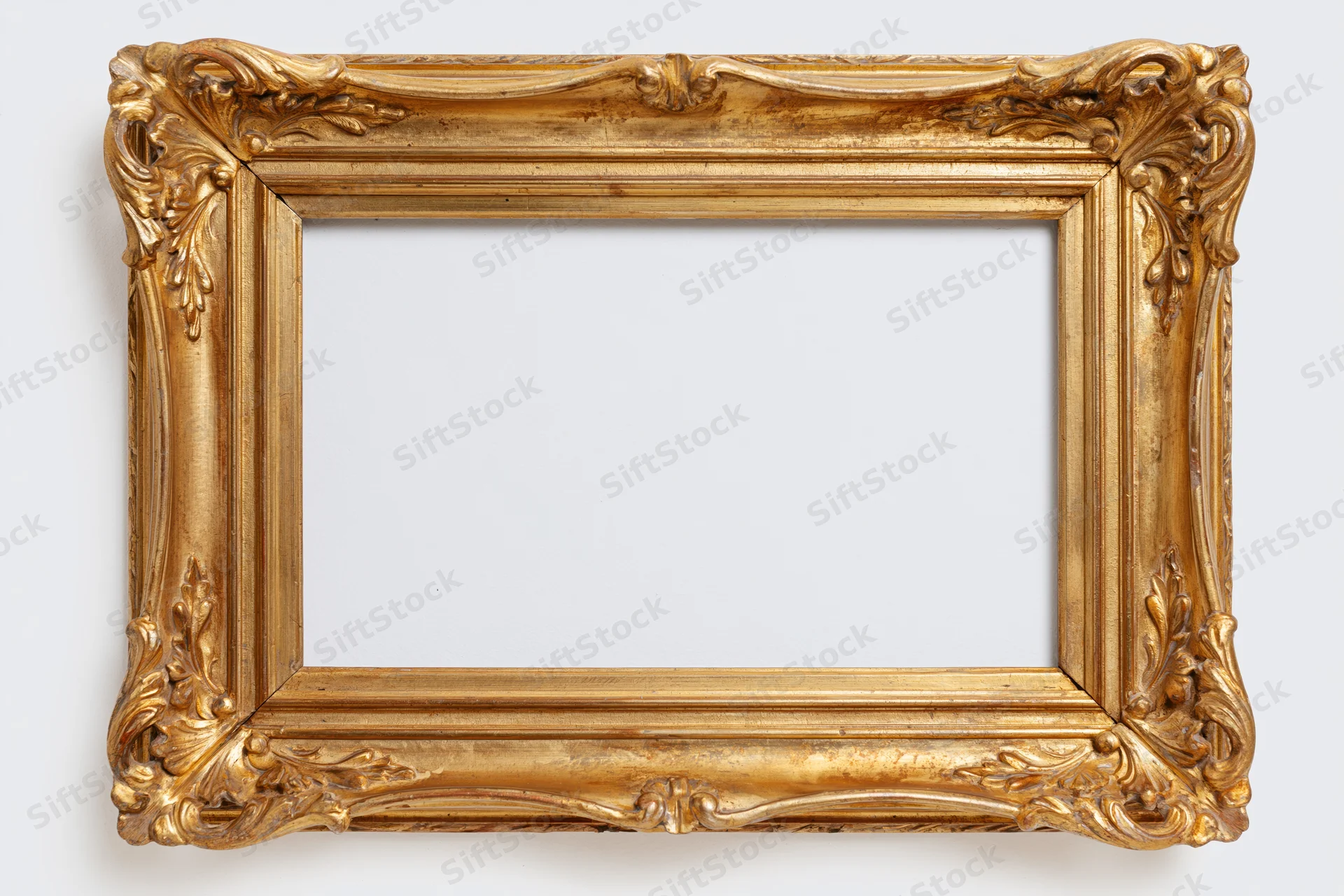 Ornate gilded wooden picture frame with carved floral details on white background