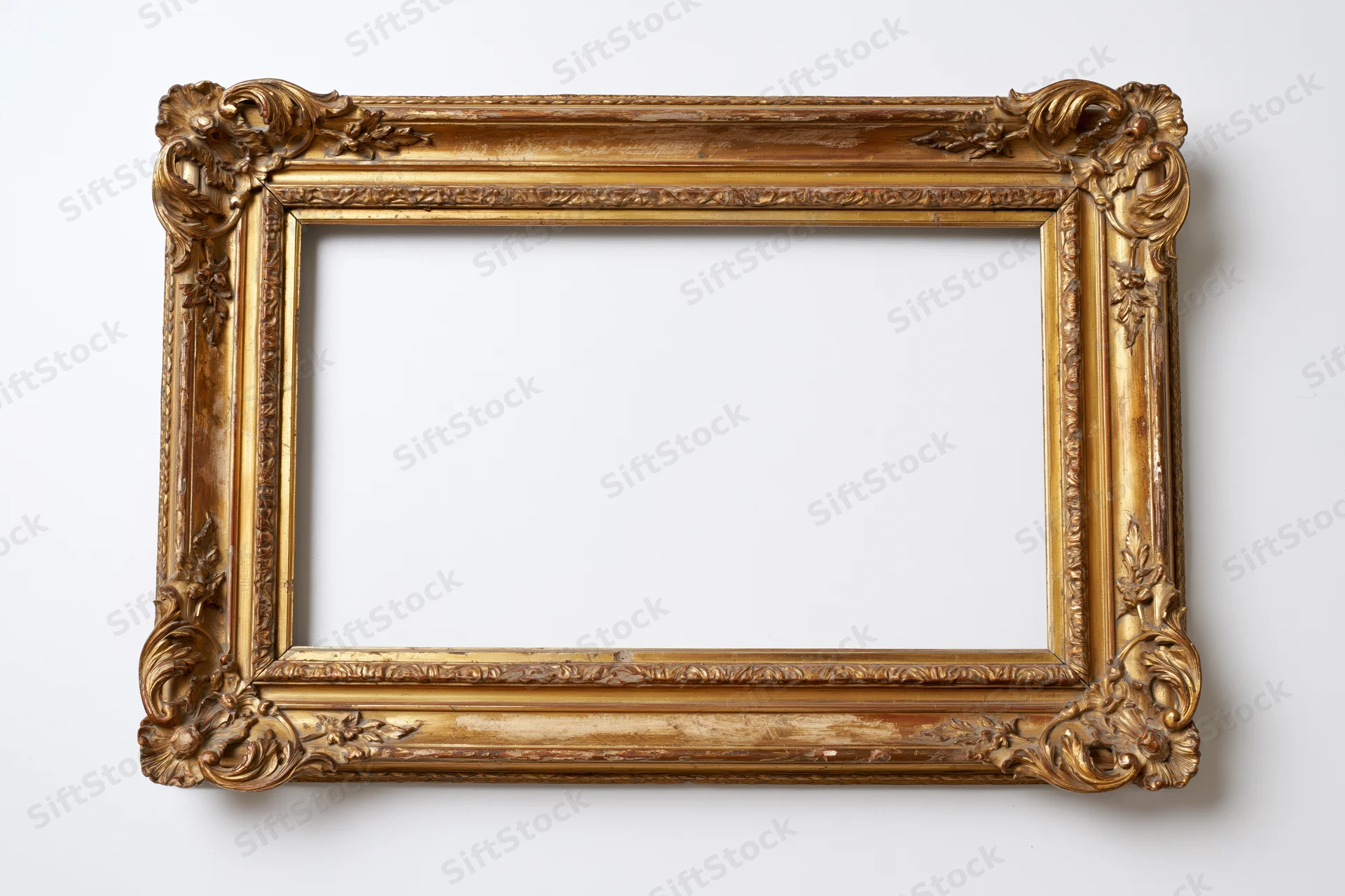 Ornate antique gilded wooden frame with carved floral details on white background