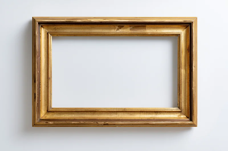 Antique gold picture frame with empty white interior hanging on a plain wall
