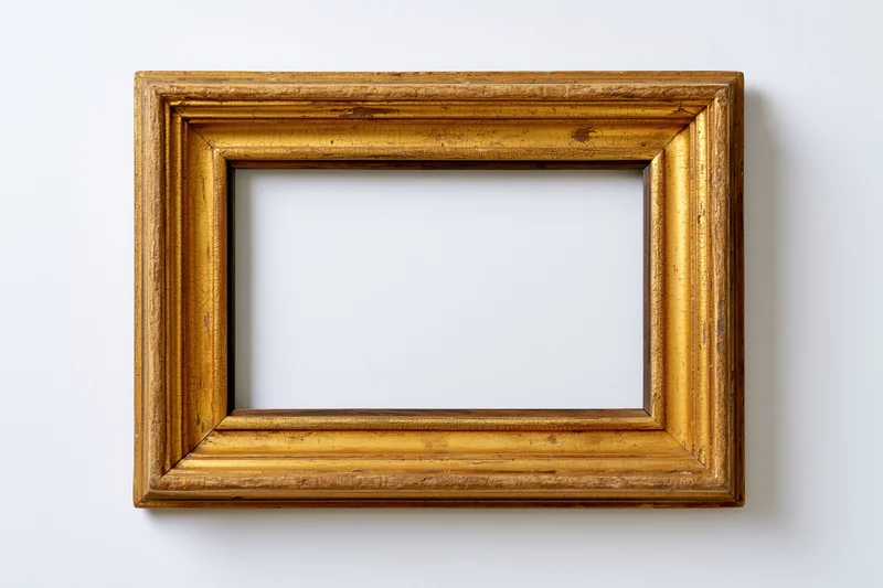 Antique gold picture frame with empty white interior hanging on a plain wall