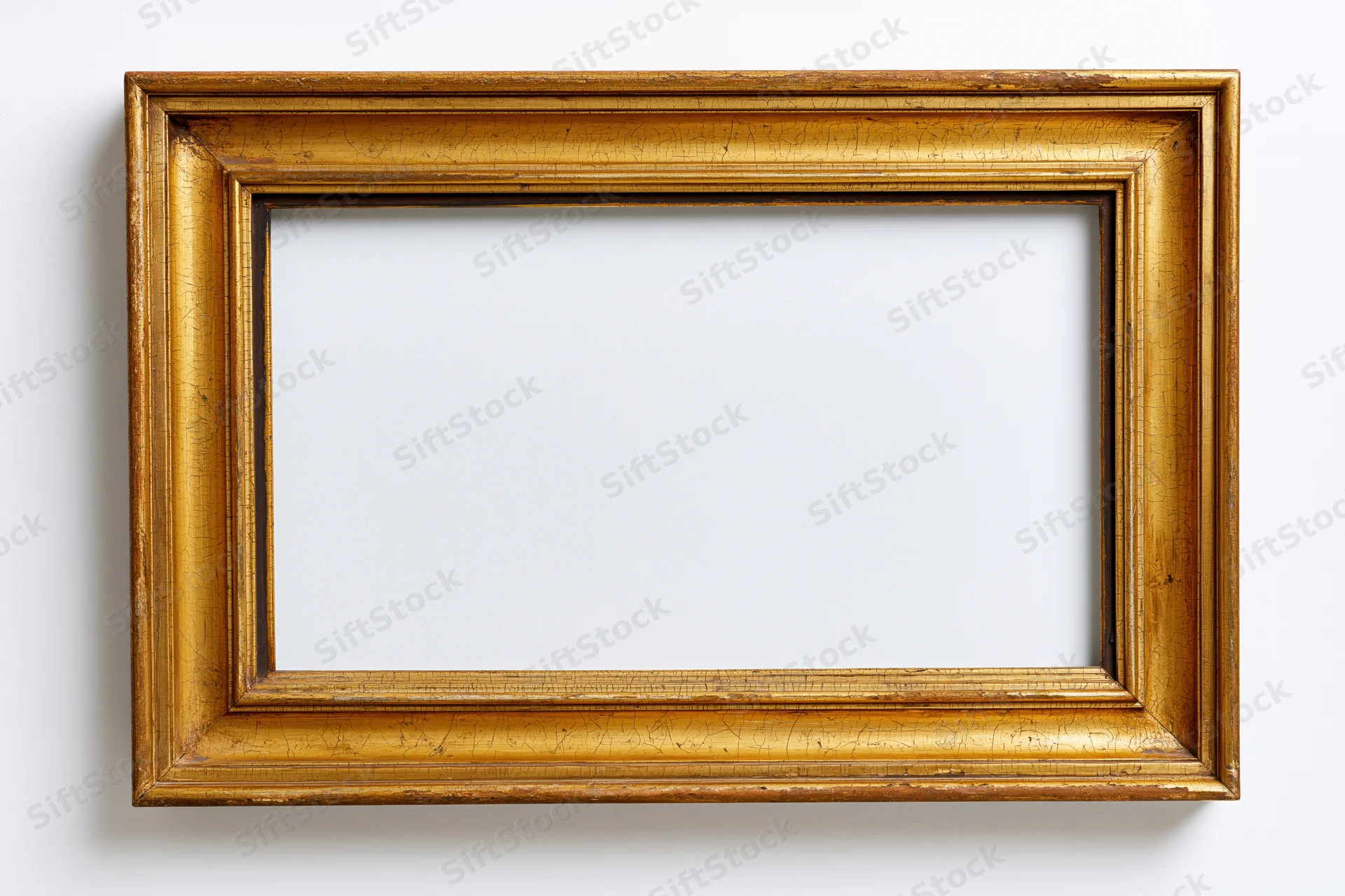 Antique gold picture frame with empty white interior hanging on a wall