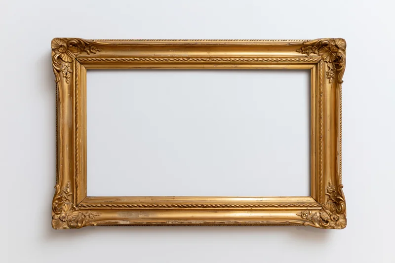 Ornate antique gold picture frame with carved corner details hanging on a white wall