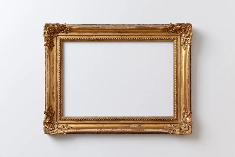 Ornate antique gold picture frame with carved floral details hanging on a white wall