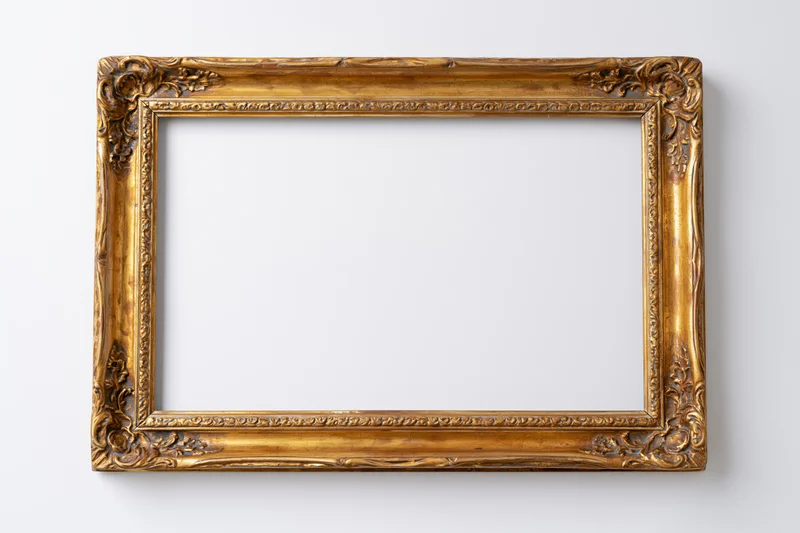 Ornate antique gold picture frame with embossed border detail hanging on white wall