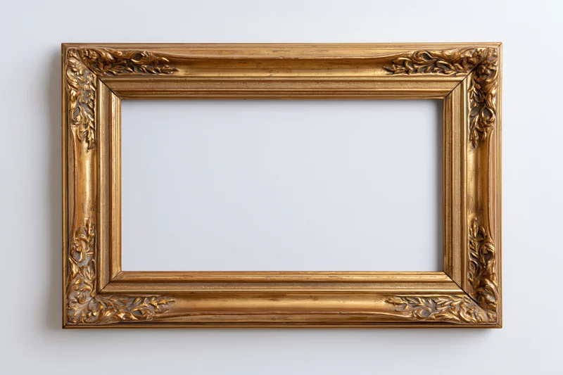 Ornate antique gold frame with embossed leaf detailing hanging on a white wall