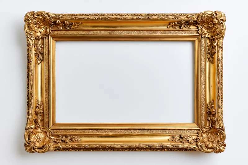 Ornate antique gold picture frame with floral carvings hanging on a white wall