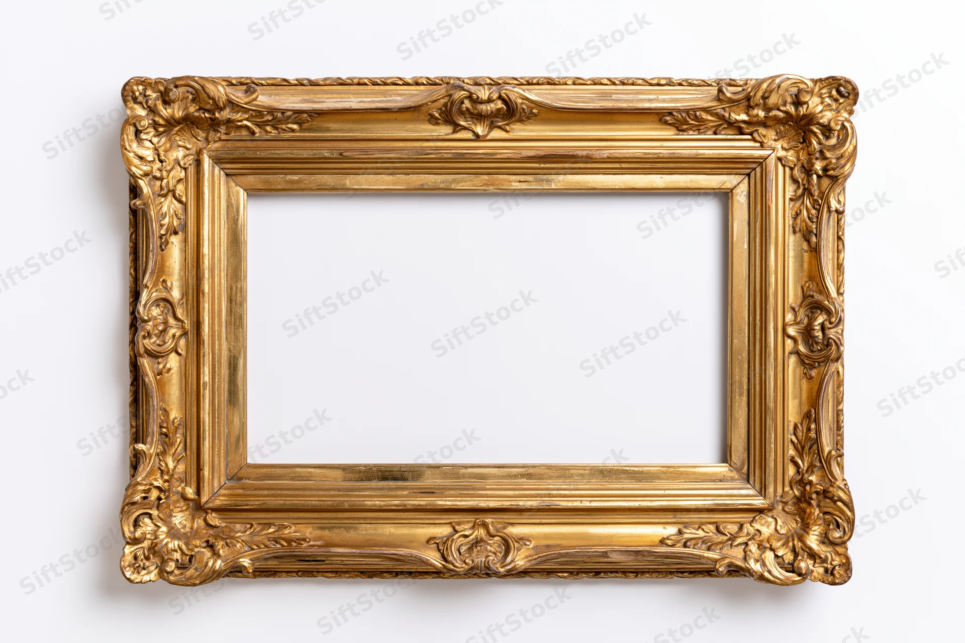 Ornate antique gold picture frame with intricate carvings photographed flat against white background