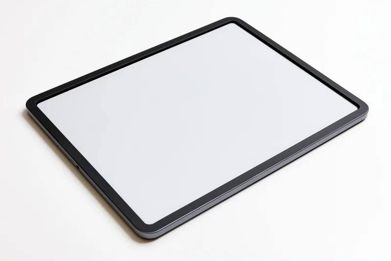 Black tablet with white screen lying flat on white surface