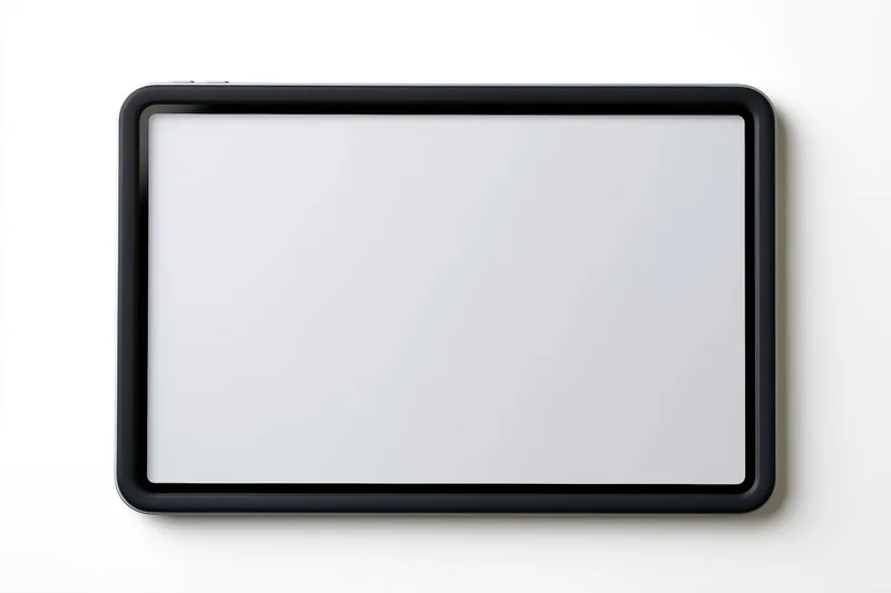 Black tablet with blank white screen lying flat on white surface