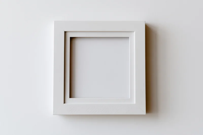 White blank photo frame hanging on a plain wall