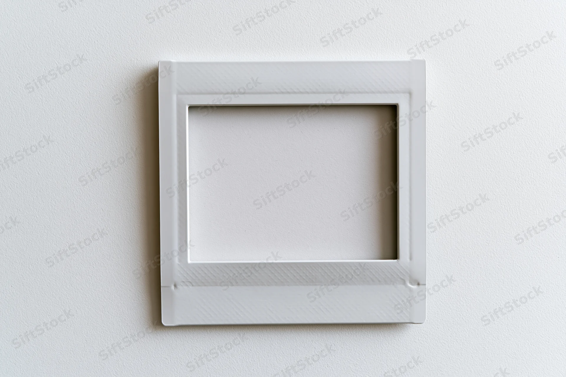 Blank white instax mini photo frame lying flat on a white surface