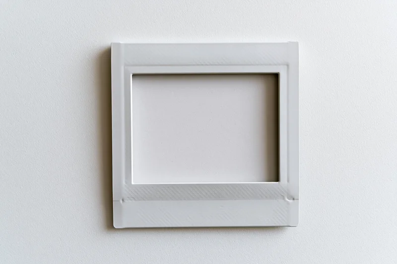 Blank white instax mini photo frame lying flat on a white surface