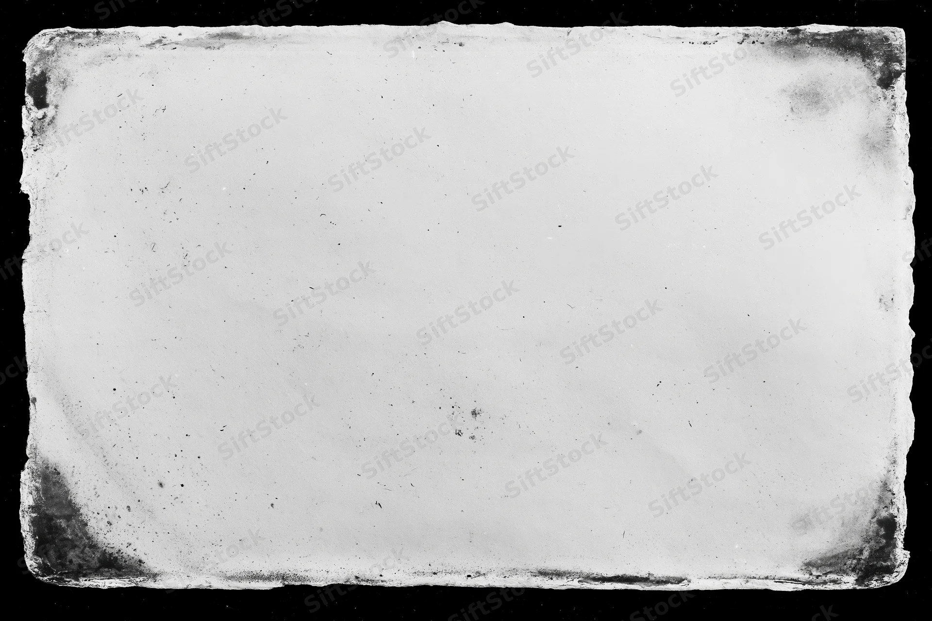 Aged photographic paper with distressed edges lying flat on black background