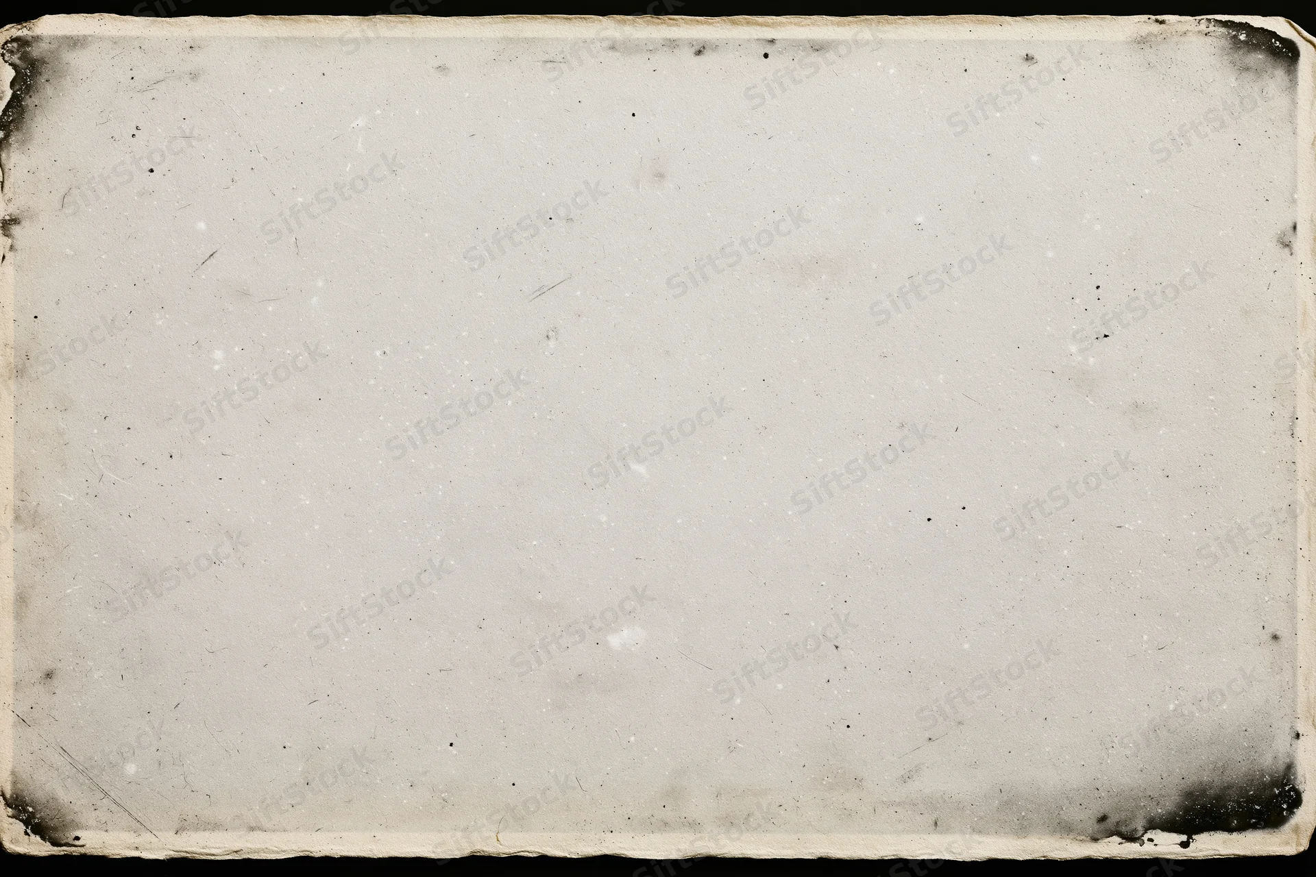Aged photographic paper with darkened corners and surface imperfections lying flat