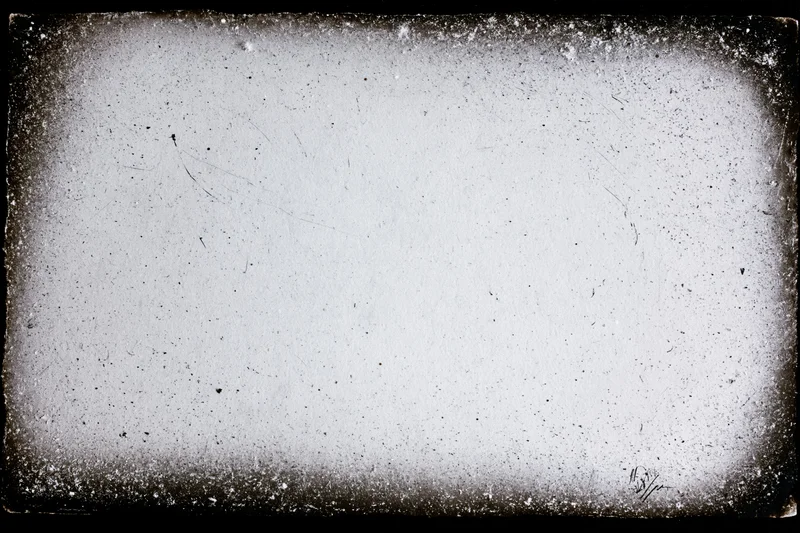 Aged photographic paper with darkroom border burn and speckled texture