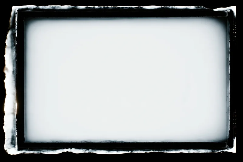 Blank analog film frame with dark textured border on black background
