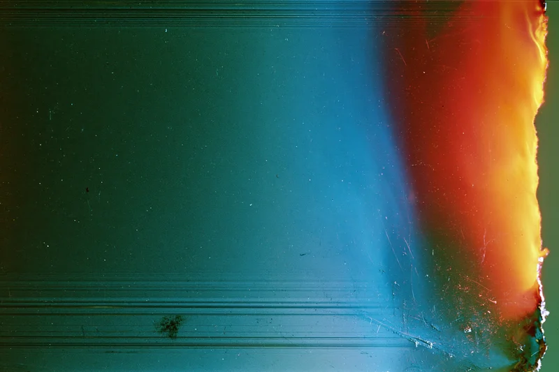 Damaged film frame with light leak and color gradient along the edge