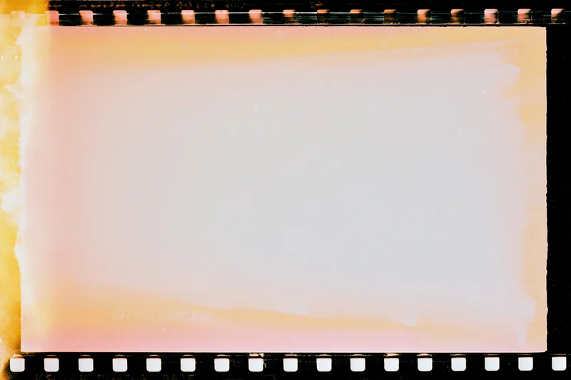 Blank overexposed 35mm film frame with light leak bleed and sprocket holes