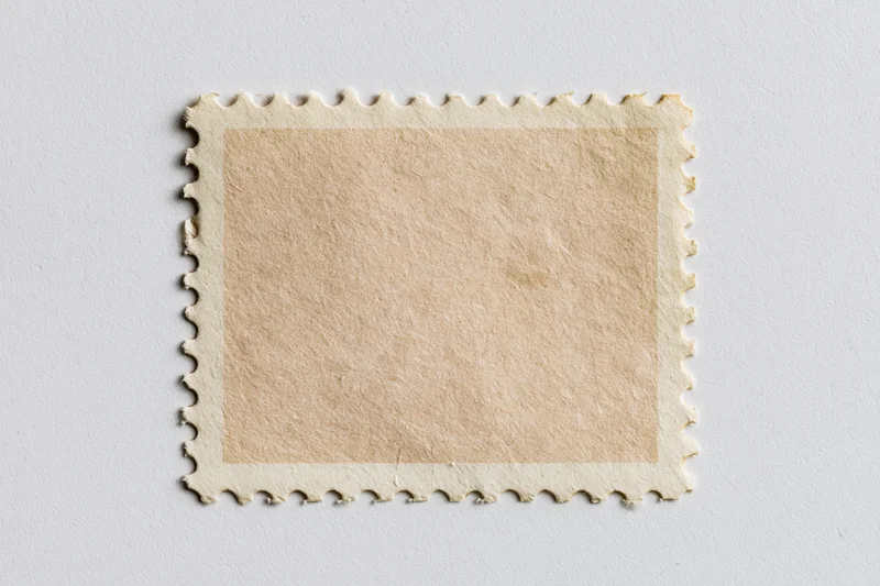 Blank postage stamp with perforated edges on white background