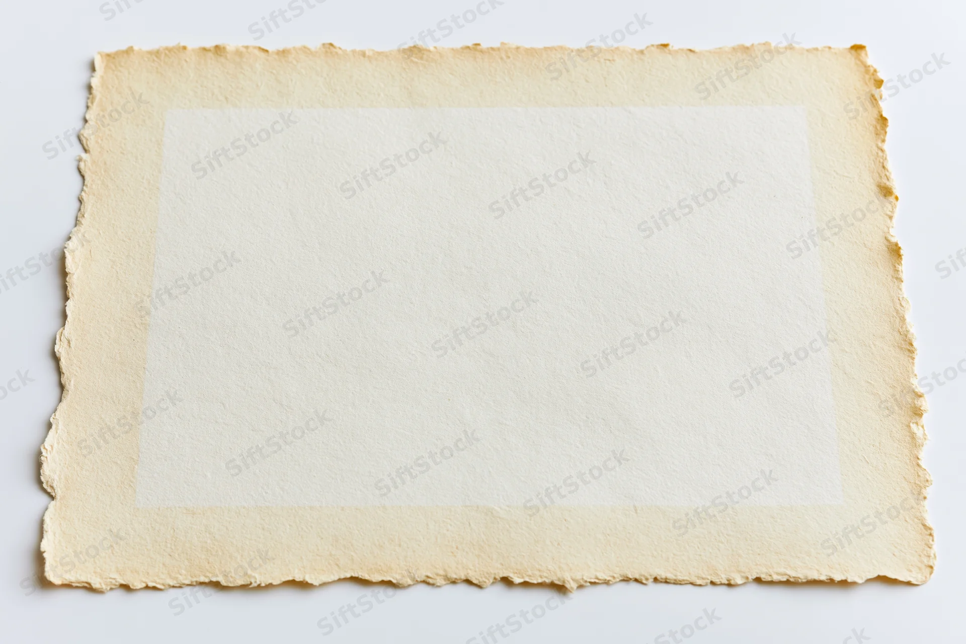 Vintage paper with deckled edges lying flat on white background