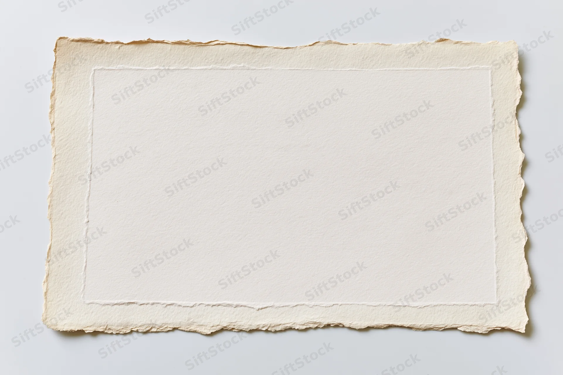 Blank vintage paper with deckled edges lying flat on white surface