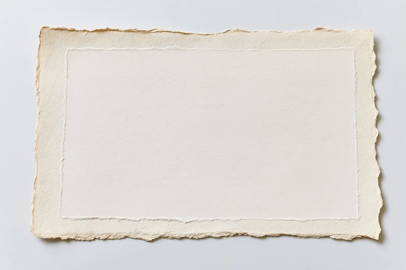 Blank vintage paper with deckled edges lying flat on white surface