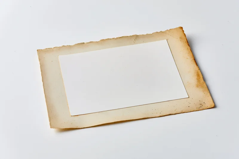 Vintage photo print with blank white center and aged torn edges on white background