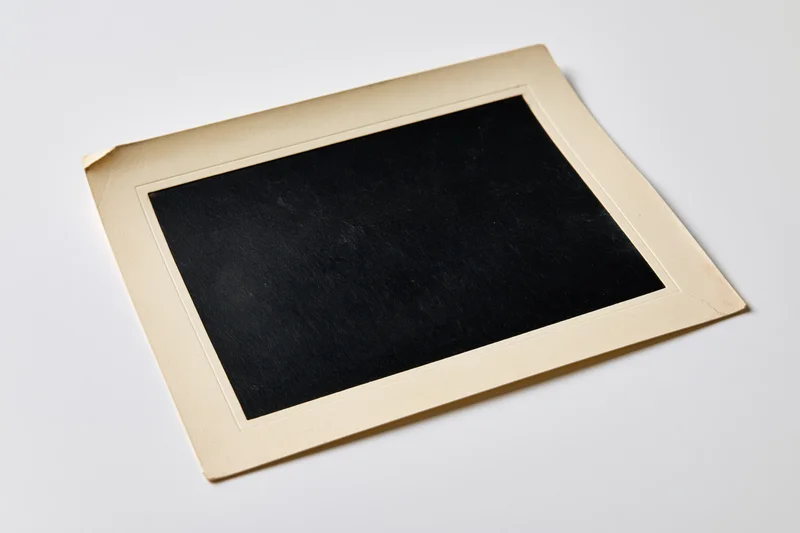 Vintage blank photo print with beige border lying flat on white surface