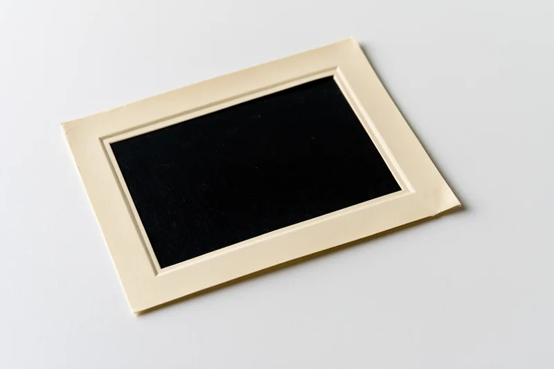 Blank vintage photo print lying flat on white surface with beige border