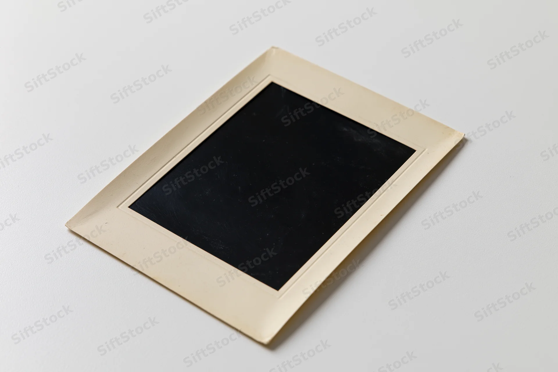 Vintage blank photo print lying flat on white surface with beige border