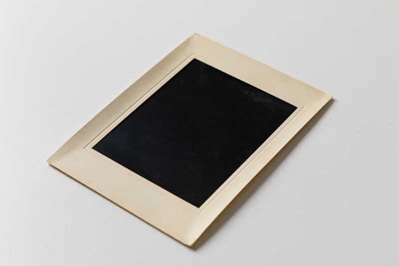 Vintage blank photo print lying flat on white surface with beige border