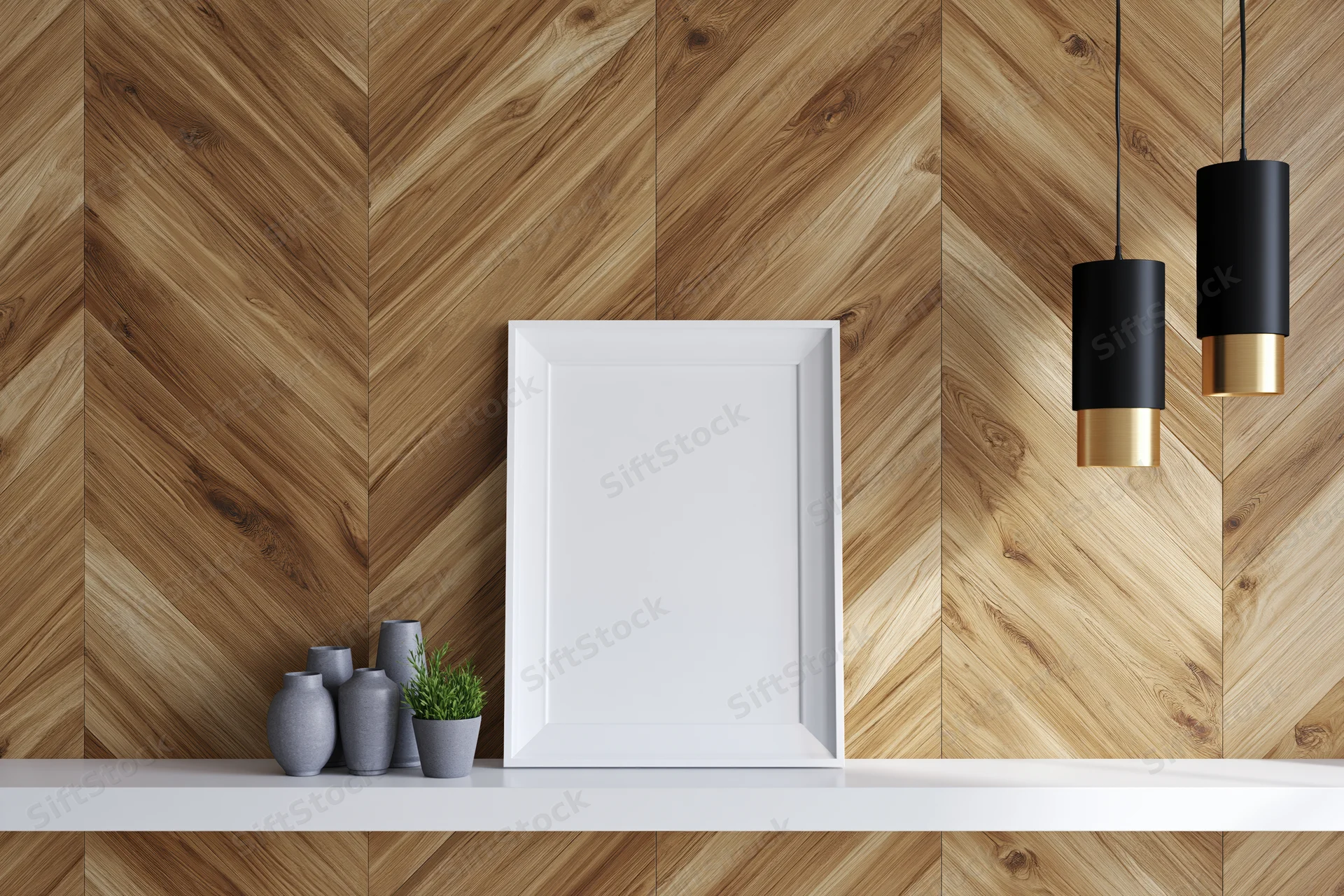 Blank white frame leaning on a white shelf against a herringbone wood wall with pendant lights and small vases