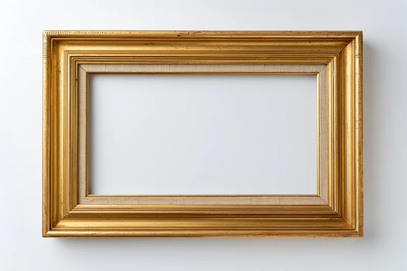 Empty antique gold picture frame hanging on white wall