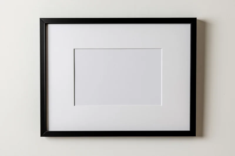 Black picture frame with white mat mounted flat on a wall