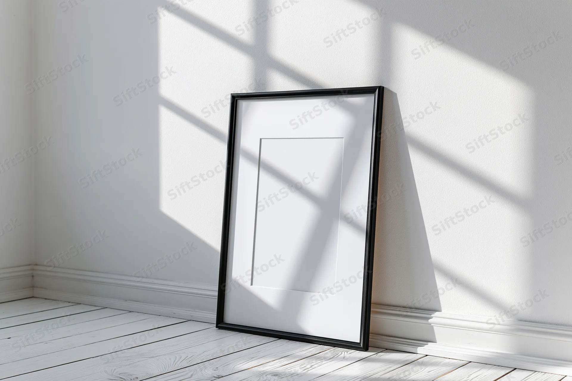 Black picture frame with white mat leaning against white wall in sunlit corner of minimalist room