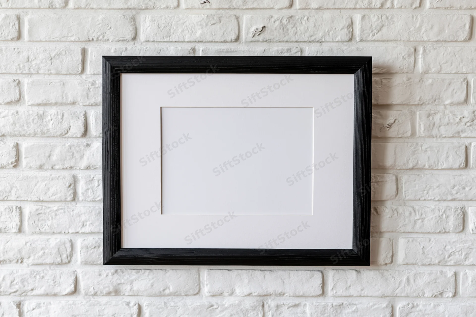 Black wooden picture frame with white mat hanging on white brick wall