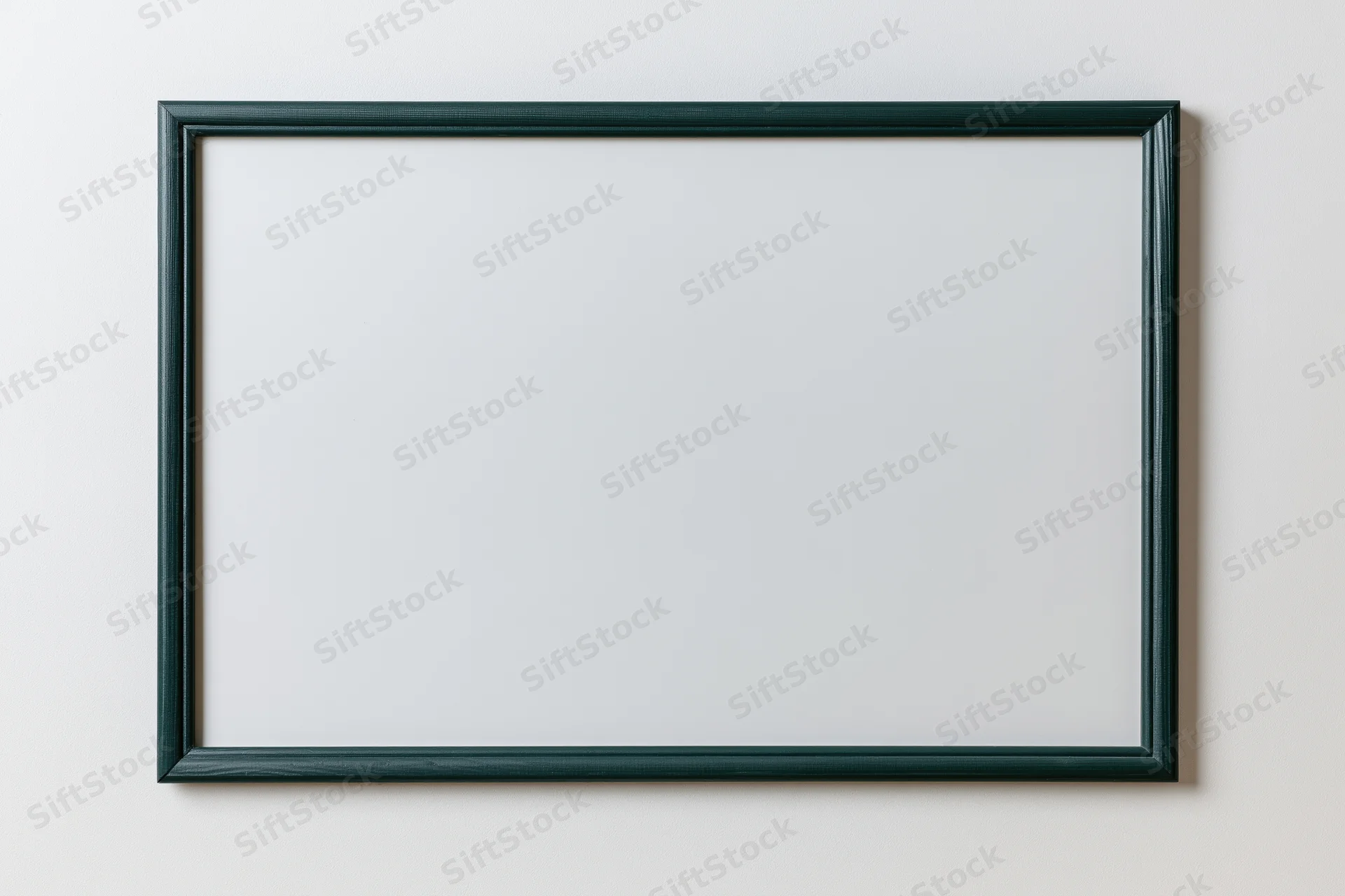 Dark green framed chalkboard with blank white surface mounted on a wall