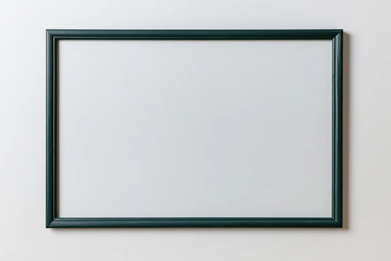 Dark green framed chalkboard with blank white surface mounted on a wall
