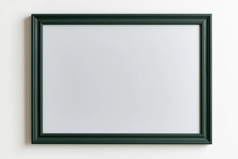 Dark green frame with blank white surface hanging on a wall