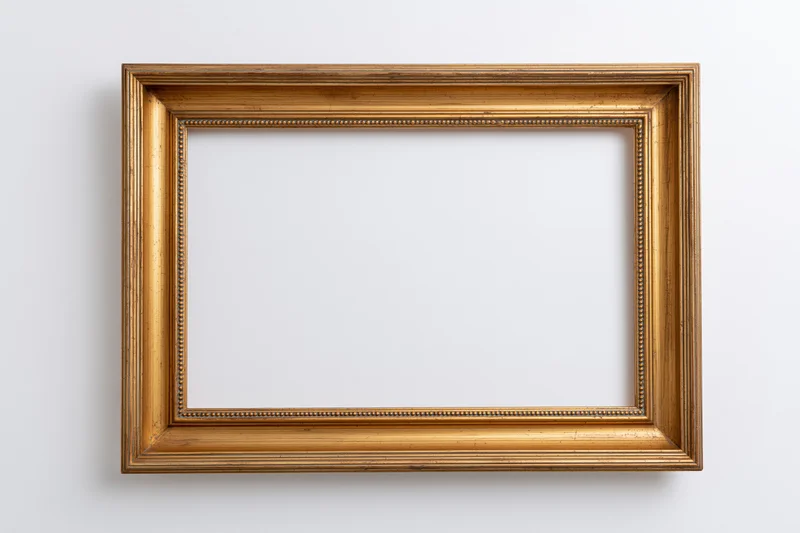 Empty gold ornate picture frame hanging on white wall