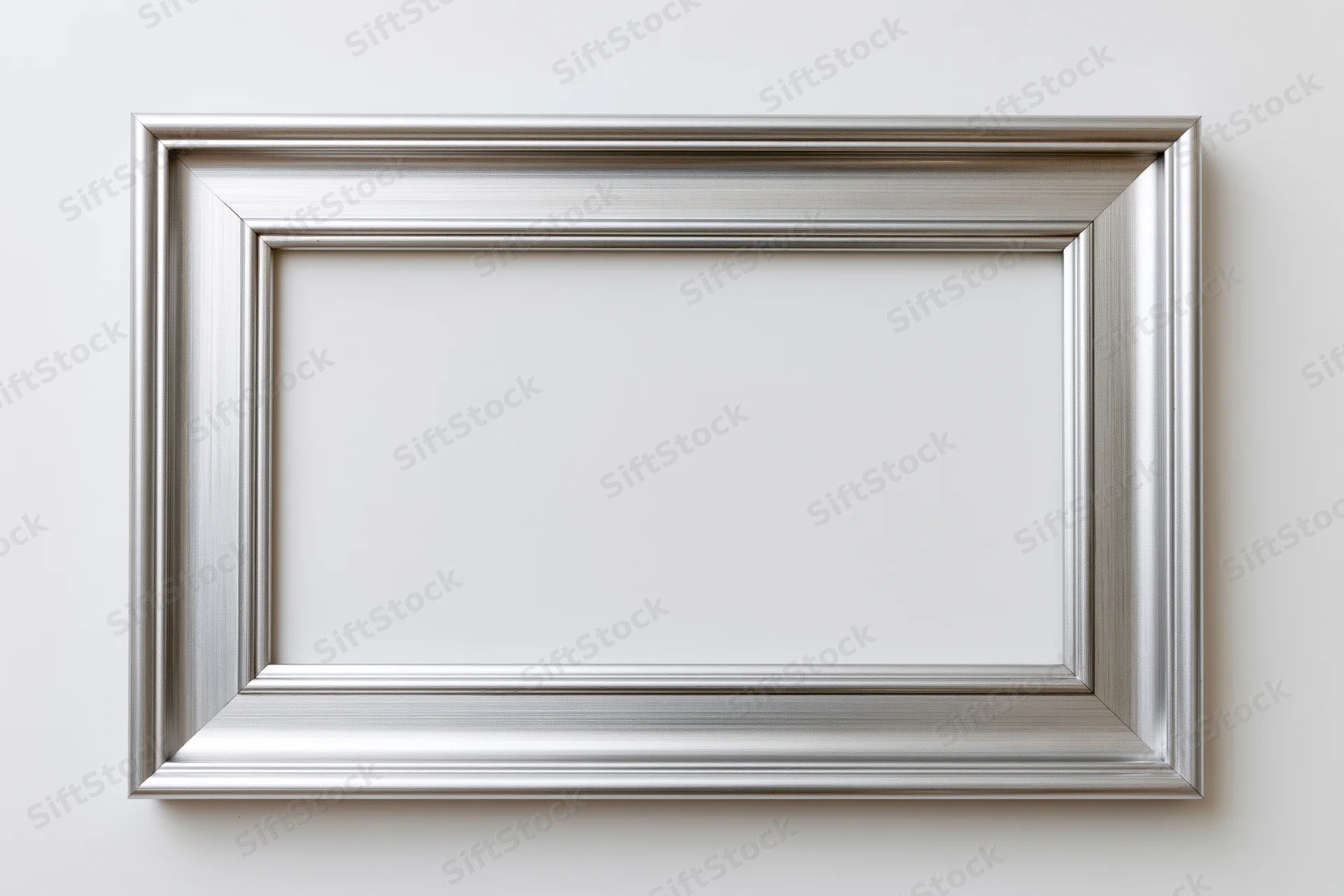 Silver picture frame hanging on white wall with empty center for display