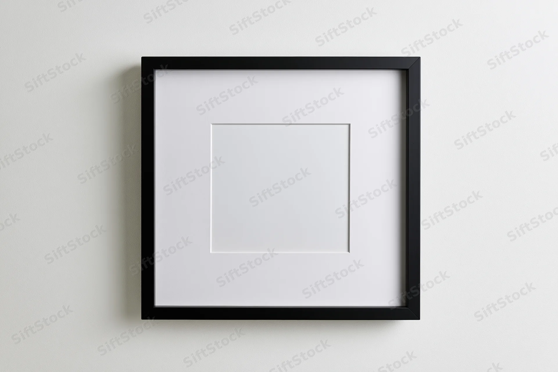 Black square frame with white mat centered on a plain wall