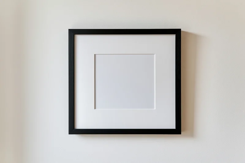 Black square frame with white mat mounted flush on a beige wall