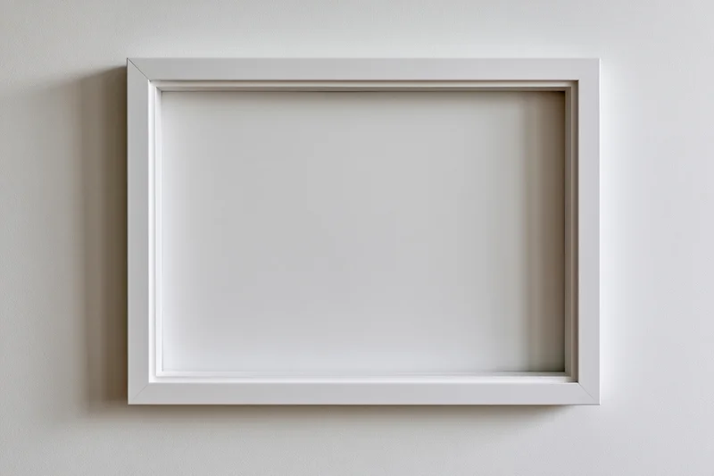 White empty picture frame hanging on a plain wall