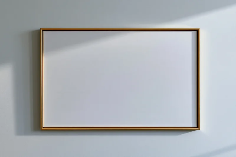 Gold-framed blank canvas hanging on a white wall with soft shadows