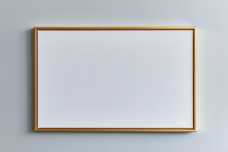 Gold-framed blank canvas hanging on a light gray wall