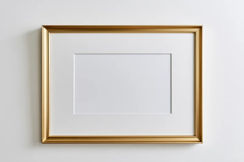 Gold picture frame with blank white mat mounted on a white wall