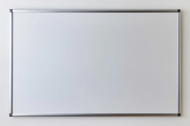 Empty white dry-erase board with aluminum frame mounted on a wall
